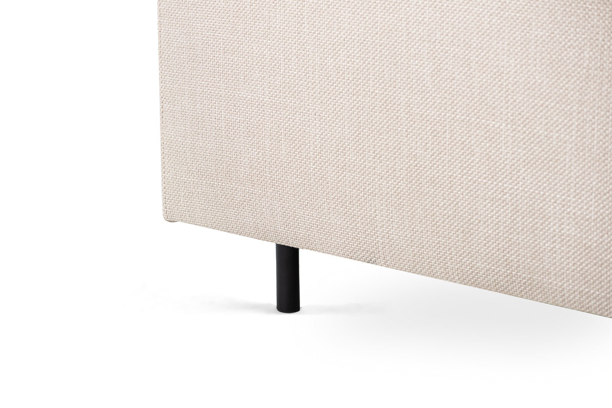 Close-up van de onderste hoek van de 3 zits hoek rechts sofa, in Bjorn 24 stof (W460 beige), met een zwarte cilindrische metalen poot tegen een witte achtergrond.