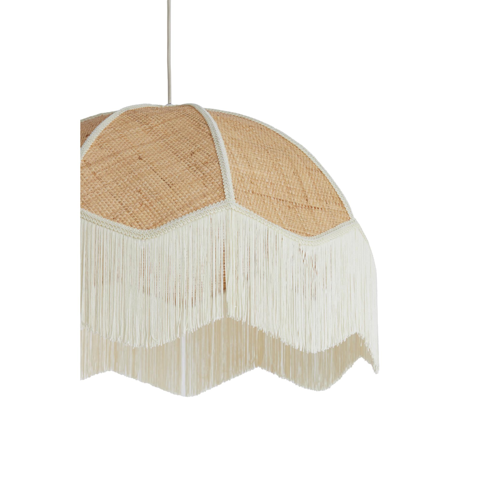 Een koepelvormige geweven hanglampenkap met witte franjes hangt aan een snoer. De lampenkap heeft een natuurlijke rotanstructuur die een rustieke toets toevoegt. De witte franjes creëren een zacht, elegant silhouet.