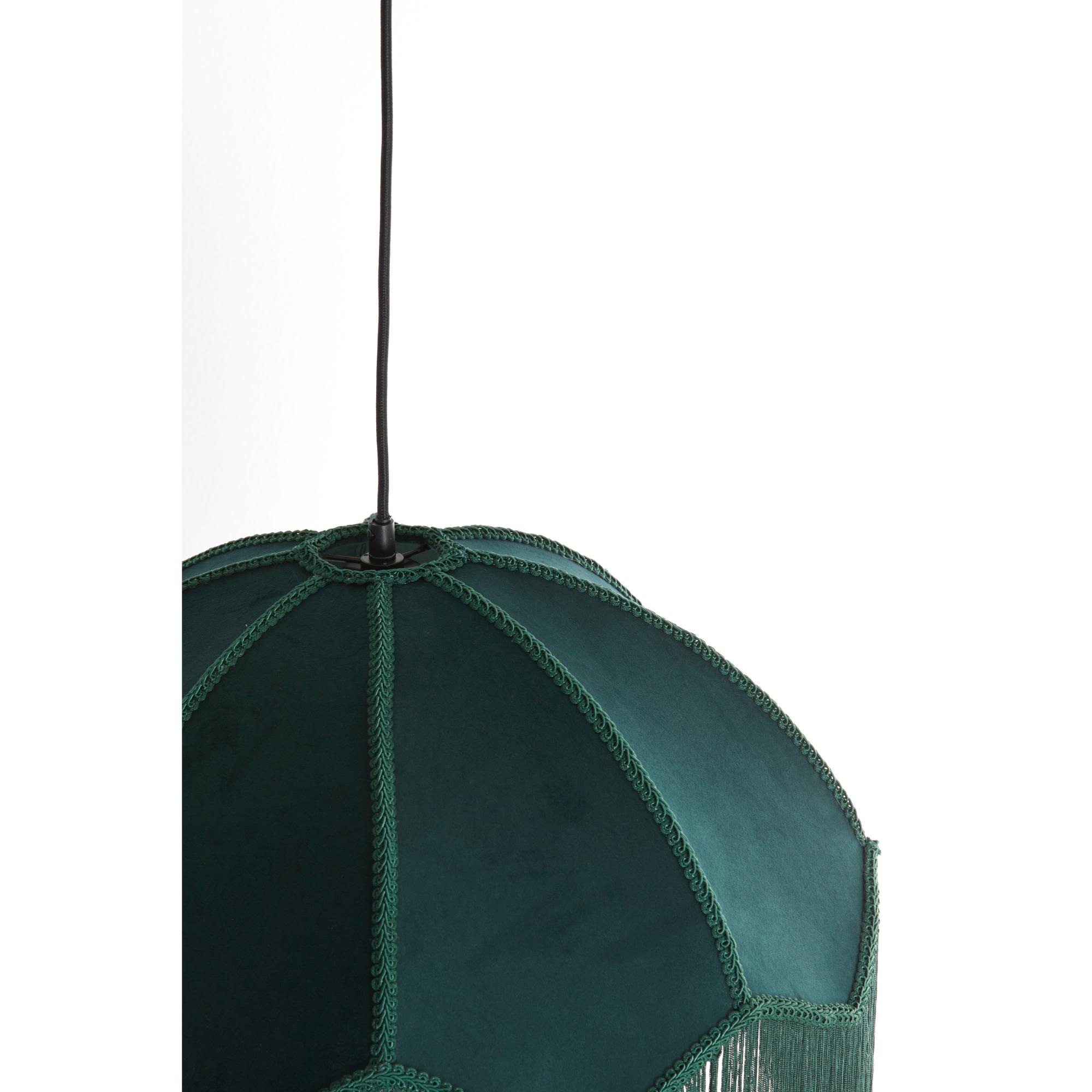 Een groene hanglampenkap met een gevlochten rand en franjes hangt aan een zwart snoer tegen een witte achtergrond.