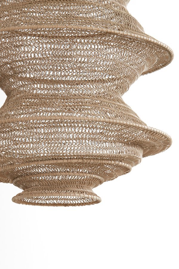 Close-up van een ingewikkeld geweven lampenkap van natuurlijke vezels met een spiraalpatroon. Het ontwerp heeft een gelaagde, conische vorm en een gestructureerd oppervlak, tegen een effen witte achtergrond.