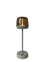 Een moderne tafellamp met een strakke, grijze cilindrische basis en steel, bekroond met een reflecterende, goudkleurige koepelvormige kap. De lamp brandt en werpt een warme gloed.