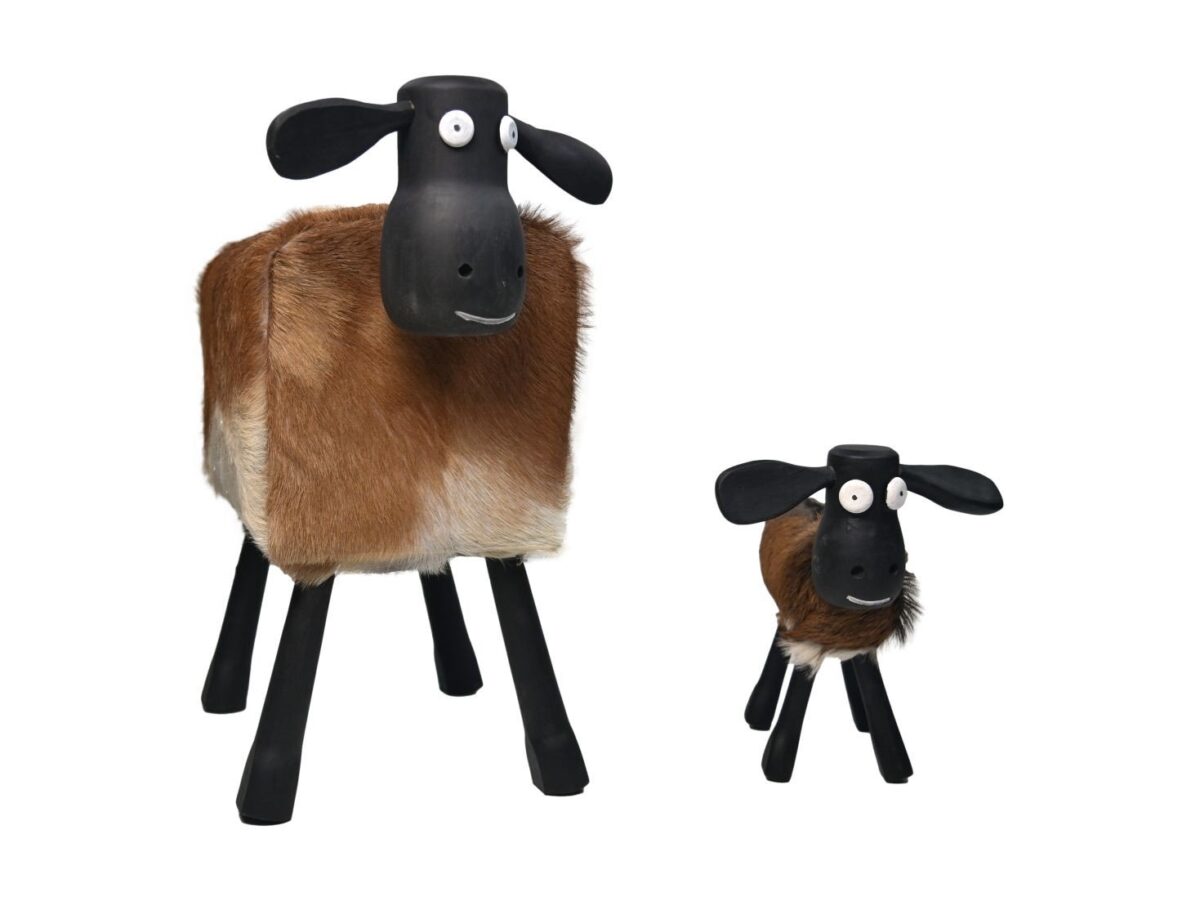 Twee gestileerde schapenbeeldjes staan tegen een witte achtergrond. Beide hebben zwarte koppen en poten, met lichamen bedekt met bruin en wit pluizig materiaal. Het grotere schaap heeft een kalme uitdrukking, terwijl het kleinere schaap er iets opzij uitziet.