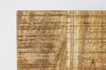 Close-up van een houten tafelblad met een rijke textuur met zichtbare nerfpatronen. Het hout heeft een lichtbruine kleur en een licht ruw oppervlak. De afbeelding legt de hoek van het tafelblad vast tegen een effen witte achtergrond.