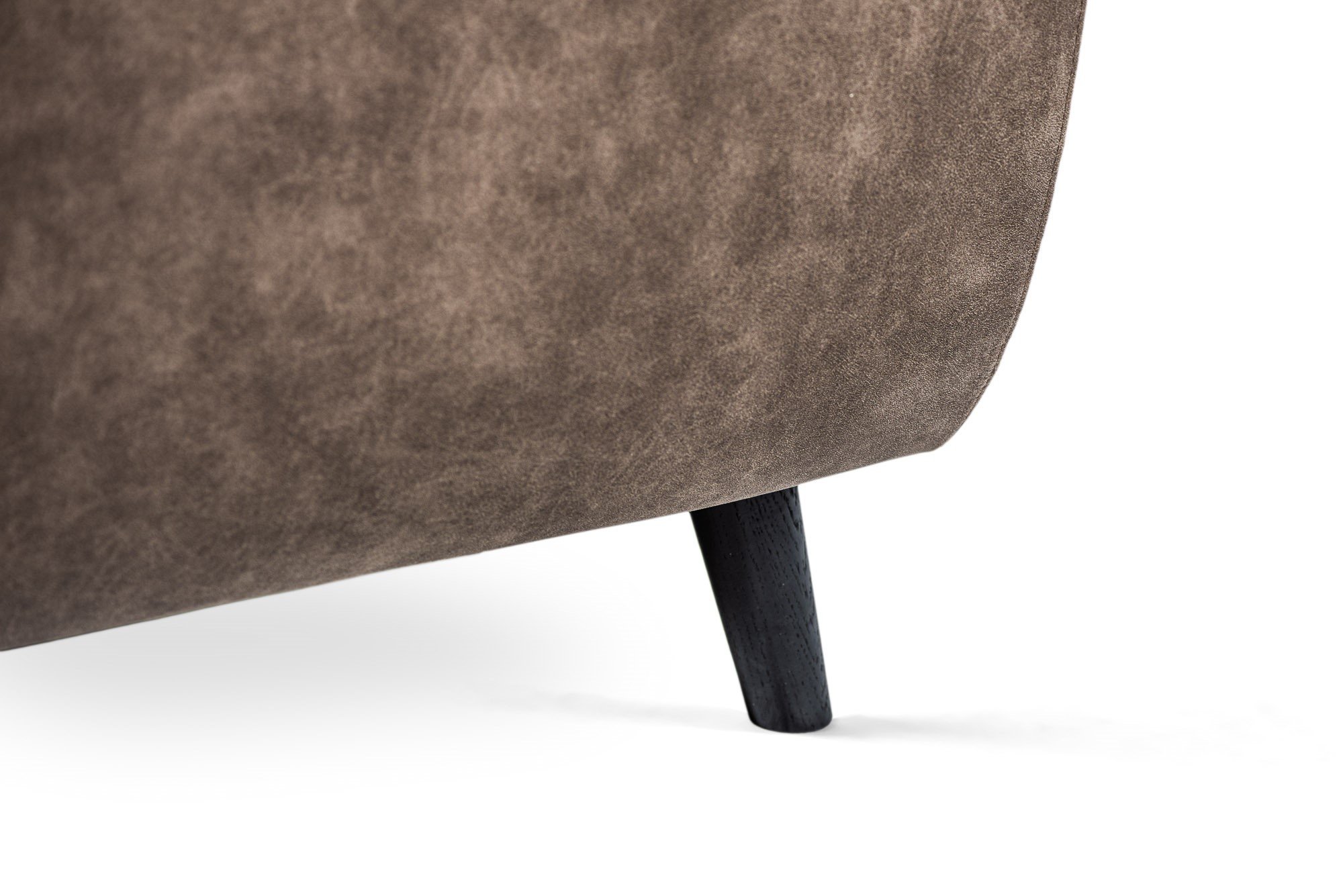 Close-up van de onderste hoek van de 3 zits hoek links sofa in stof Yuma 34, S520 taupe, met een enkele zwarte houten poot tegen een witte achtergrond.