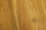 Close-up van een houten oppervlak met een natuurlijk, gestructureerd nerfpatroon. Het hout heeft lichte tot middelbruine tinten met zichtbare knopen en subtiele variaties in kleur en textuur, wat de organische uitstraling benadrukt.