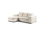 Een beige hoekbank met zachte kussens en een chaise longue aan de linkerkant, tegen een witte achtergrond.