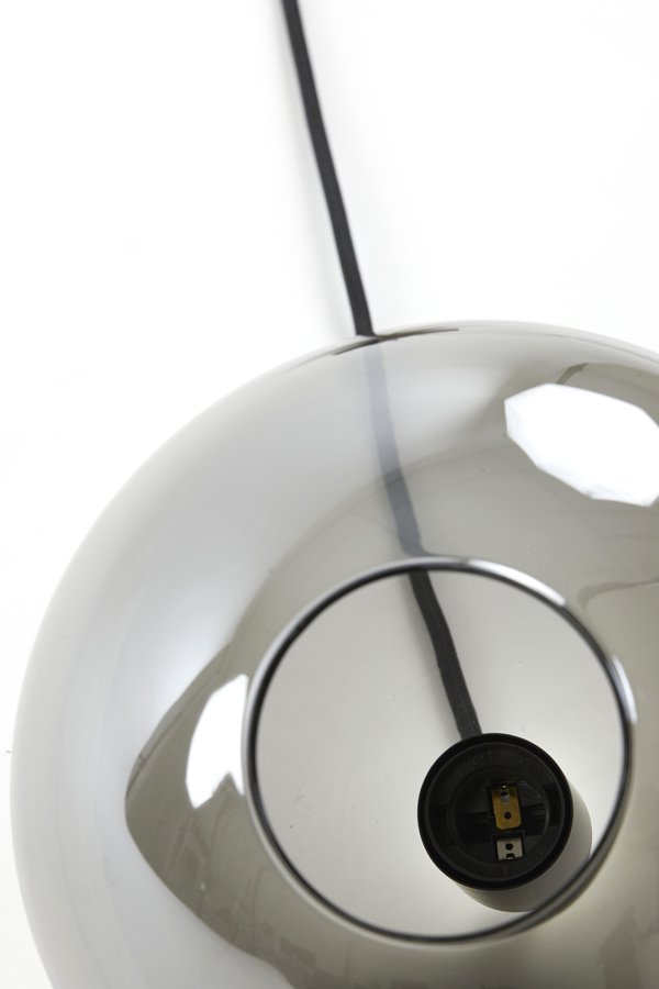 Een close-up van een moderne, glanzende metalen lampenvoet met een lege fitting. Een zwart elektrisch snoer steekt uit de voet, wat contrasteert met de witte achtergrond. Het oppervlak van de lamp reflecteert het omringende licht.
