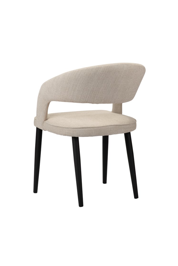 Een moderne stoel met een lichtbeige stoffen zitting en een gebogen rugleuning. Hij heeft zwarte, slanke poten en een minimalistisch design, gepositioneerd op een witte achtergrond.