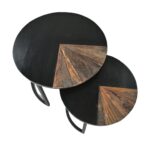 Twee ronde in elkaar passende tafels met zwarte oppervlakken. Elke tafel heeft een sectie met een geometrisch houten patroon, wat een contrast vormt met het zwarte blad. De tafels zijn gestapeld, wat een gelaagd effect geeft.