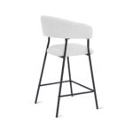 Een moderne barkruk met een witte, gewatteerde zitting en rugleuning, ondersteund door een zwart metalen frame met slanke poten en een voetenbankje. Het ontwerp is minimalistisch en eigentijds.