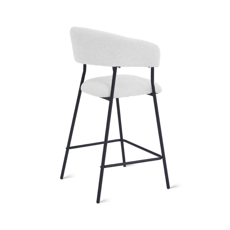 Een moderne barkruk met een witte, gewatteerde zitting en rugleuning, ondersteund door een zwart metalen frame met slanke poten en een voetenbankje. Het ontwerp is minimalistisch en eigentijds.