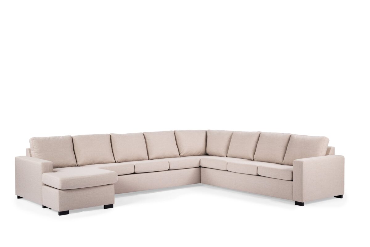 Beige L-vormige sectionele bank met een chaise longue aan de linkerkant, met zachte zit- en rugkussens. De bank heeft een minimalistisch ontwerp met donkere blokpoten en een strakke, moderne uitstraling tegen een effen witte achtergrond.