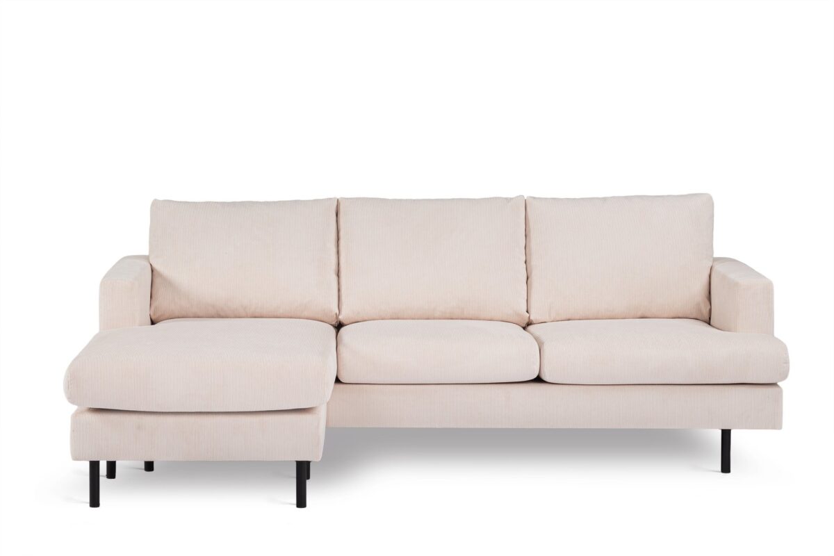 Een beige, driezits sectionele bank met een chaise longue aan de linkerkant. Het heeft eenvoudige lijnen en zwarte poten, tegen een effen witte achtergrond.