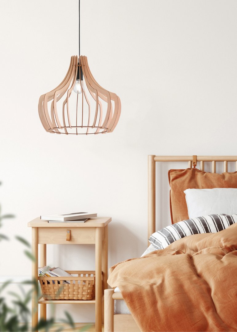 Een gezellige slaapkamer heeft een houten bed met roestkleurig beddengoed en een gestreept kussen. Een houten nachtkastje met een rieten mand en plant in de buurt complementeert een stijlvolle houten hanglamp die erboven hangt.