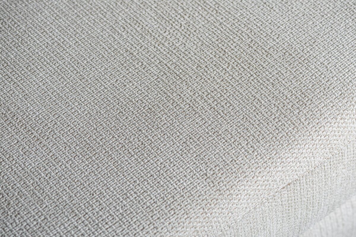 Close-up van de beige Lord 22 stof met een subtiele geweven textuur op de hoek van de 3-zits hoek rechts sofa (stof E460).