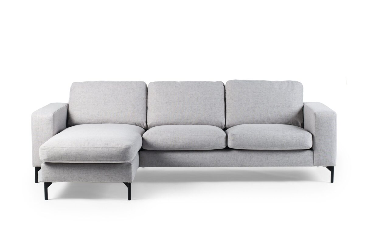 De 3 zits bank CL L+R in Valente V311 grijs stof heeft drie zitkussens, een chaise lounge aan de linkerkant en zwarte metalen poten, tegen een effen witte achtergrond.