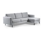De 3-zits bank CL L+R in Chloe C311 grijs is een moderne lichtgrijze sectionele bank met drie rugkussens, smalle armleuningen, zwarte metalen poten en een chaise lounge aan de rechterkant, getoond tegen een witte achtergrond.