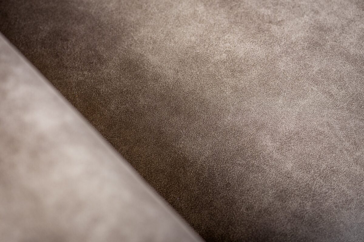 Close-up van de 3 zits bank CL L+R bekleed met de stof Savannah S520 taupe. De gladde suède textuur, subtiele kleurvariaties en fijne nerf benadrukken het pluche, fluweelachtige oppervlak.