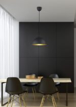 Een moderne eetkamer met een minimalistisch design heeft een houten tafel en vier zwarte stoelen. Een zwarte hanglamp hangt boven de tafel. De muren zijn donker en een doorschijnend wit gordijn bedekt een raam aan de linkerkant.
