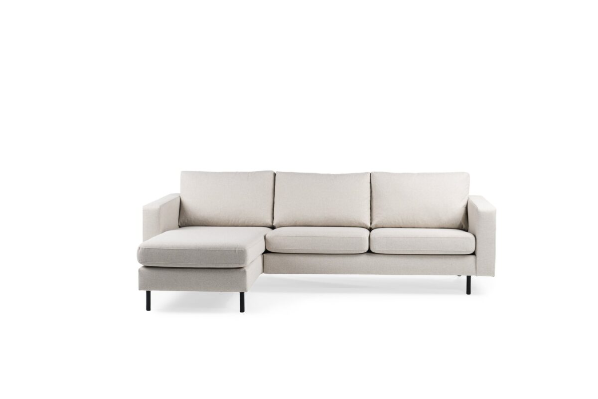 Een moderne 3-zitsbank, model CL L+R in de stof Dillon (D820 ivoor), heeft drie zit- en rugkussens, een naar links gerichte chaise lounge en slanke zwarte poten tegen een effen witte achtergrond.