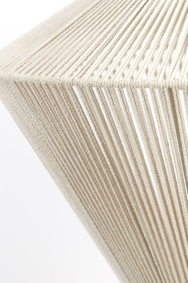 Close-up van een beige lampenkap met snoeren. De snoeren zijn strak om het frame gewikkeld, waardoor een geometrisch patroon ontstaat. De lampenkap is schuin, waardoor het gestructureerde oppervlak zichtbaar is tegen een effen witte achtergrond.