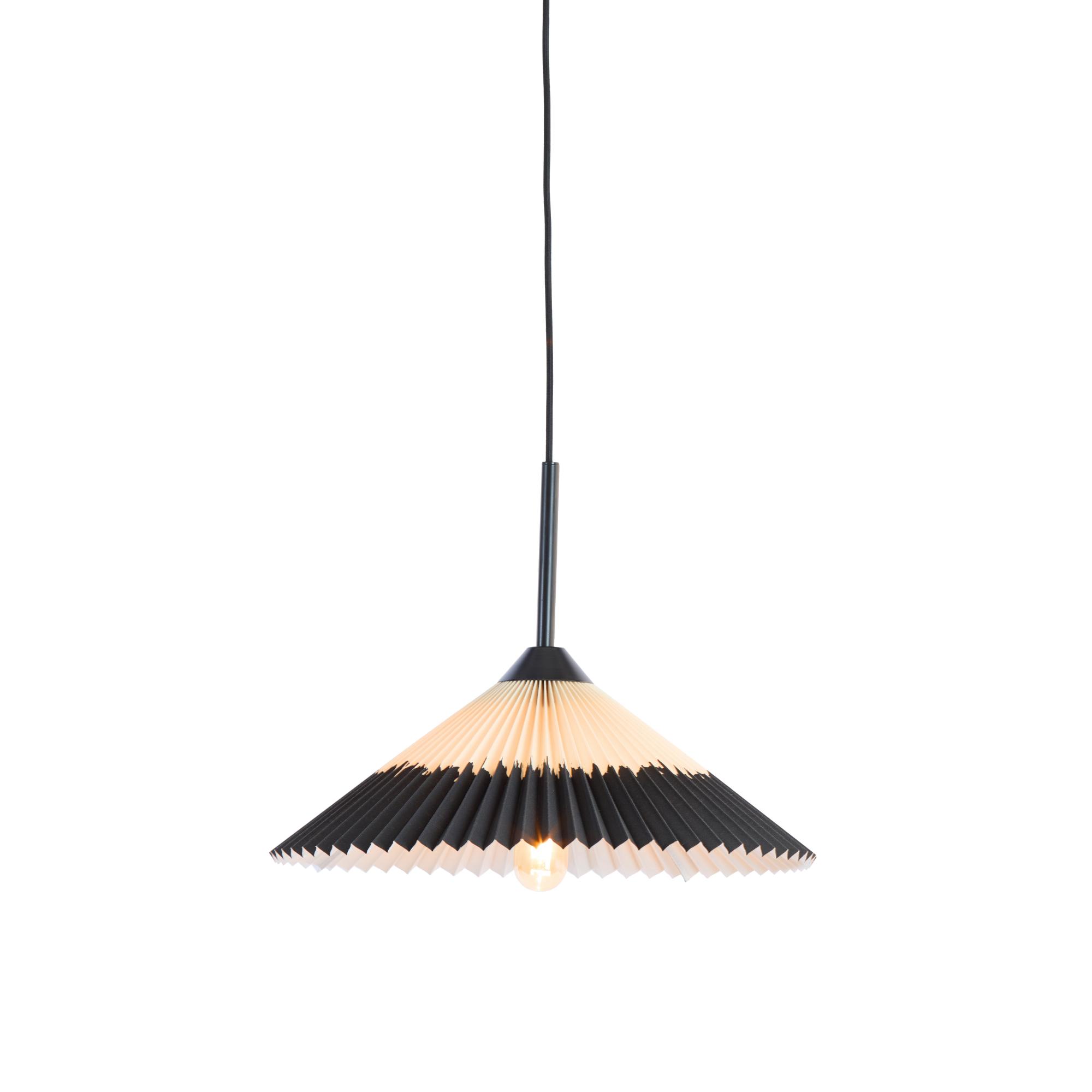 Een hanglamp met een geplooide, conische kap, met een verloop van zwart aan de bovenkant naar wit aan de onderkant. De gloeilamp is zichtbaar aan de binnenkant, opgehangen aan een zwart snoer tegen een witte achtergrond.