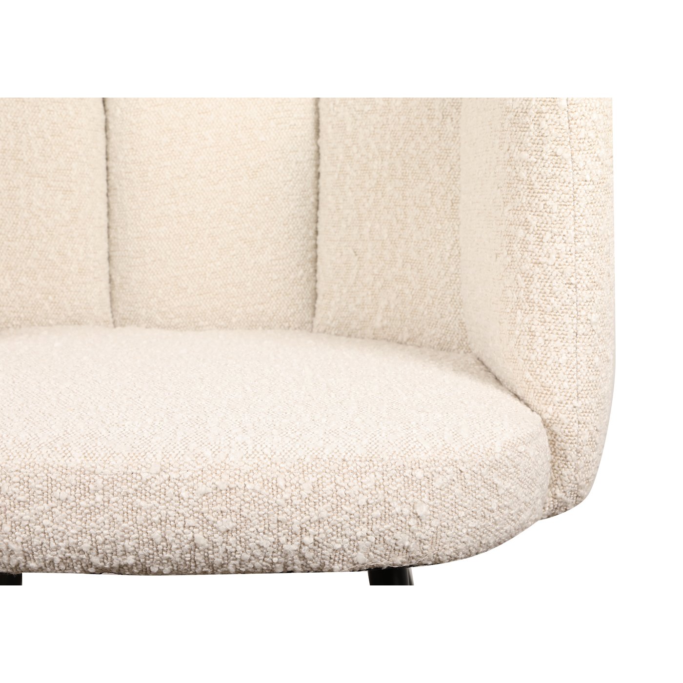 Close-up van een beige, getextureerde gestoffeerde stoel. De afbeelding toont de pluche stof en de gewatteerde rugleuning, wat het comfort en design van de stoel benadrukt. De focus ligt op de zitting en een deel van de rugleuning.