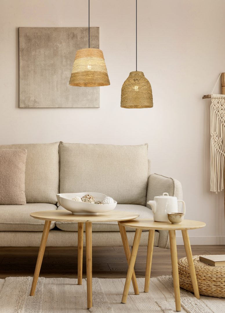 Een gezellige woonkamer met een beige bank, houten salontafels en geweven hanglampen. Een theepot en decoratieve kom staan op de tafels. Neutrale inrichting omvat een wandkleed met textuur en een canvas schilderij.