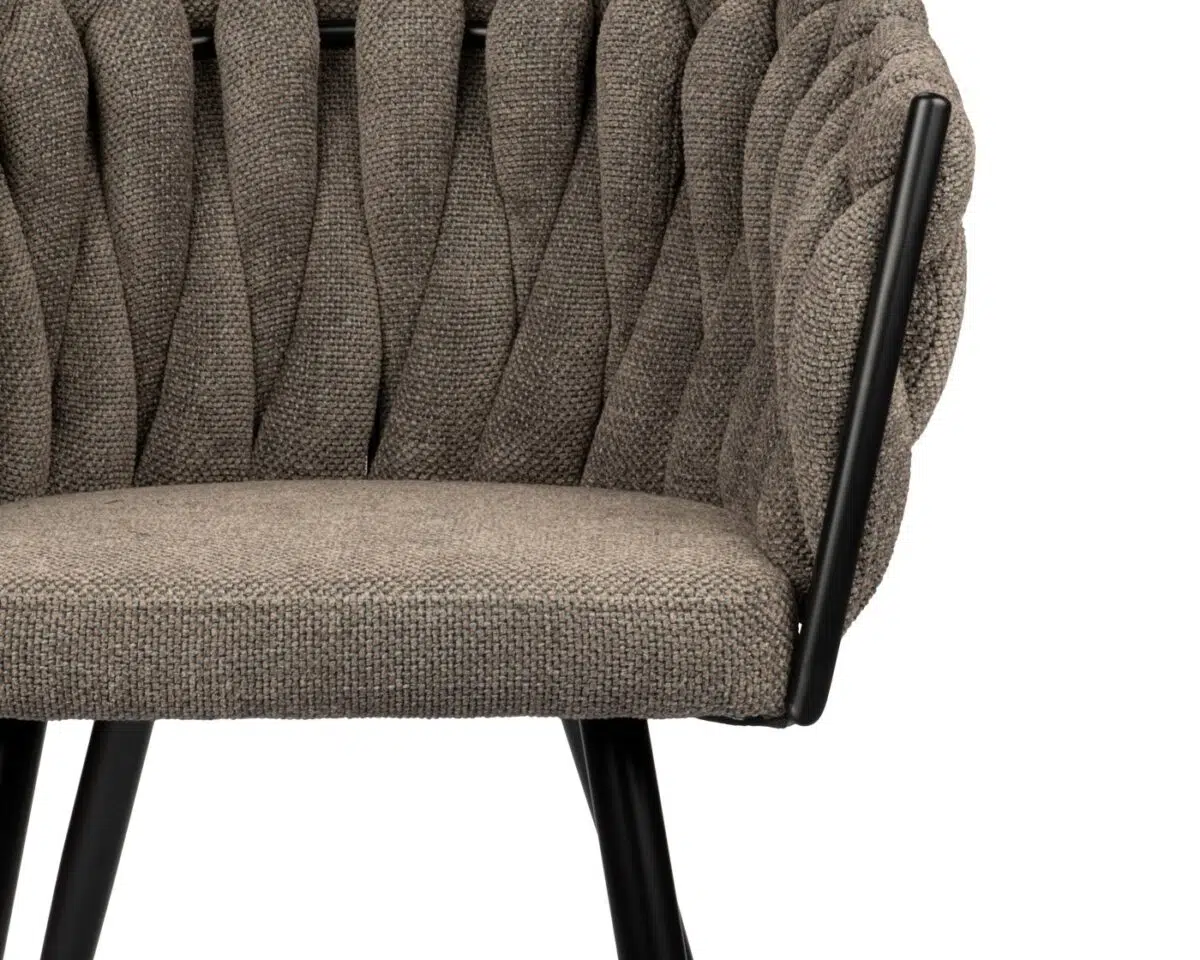 Een moderne grijze fauteuil met een getextureerd, geweven stoffen ontwerp. De stoel heeft zwarte metalen poten en armleuningframes, wat de eigentijdse look versterkt. De close-upfoto benadrukt het ingewikkelde patroon van de bekleding.