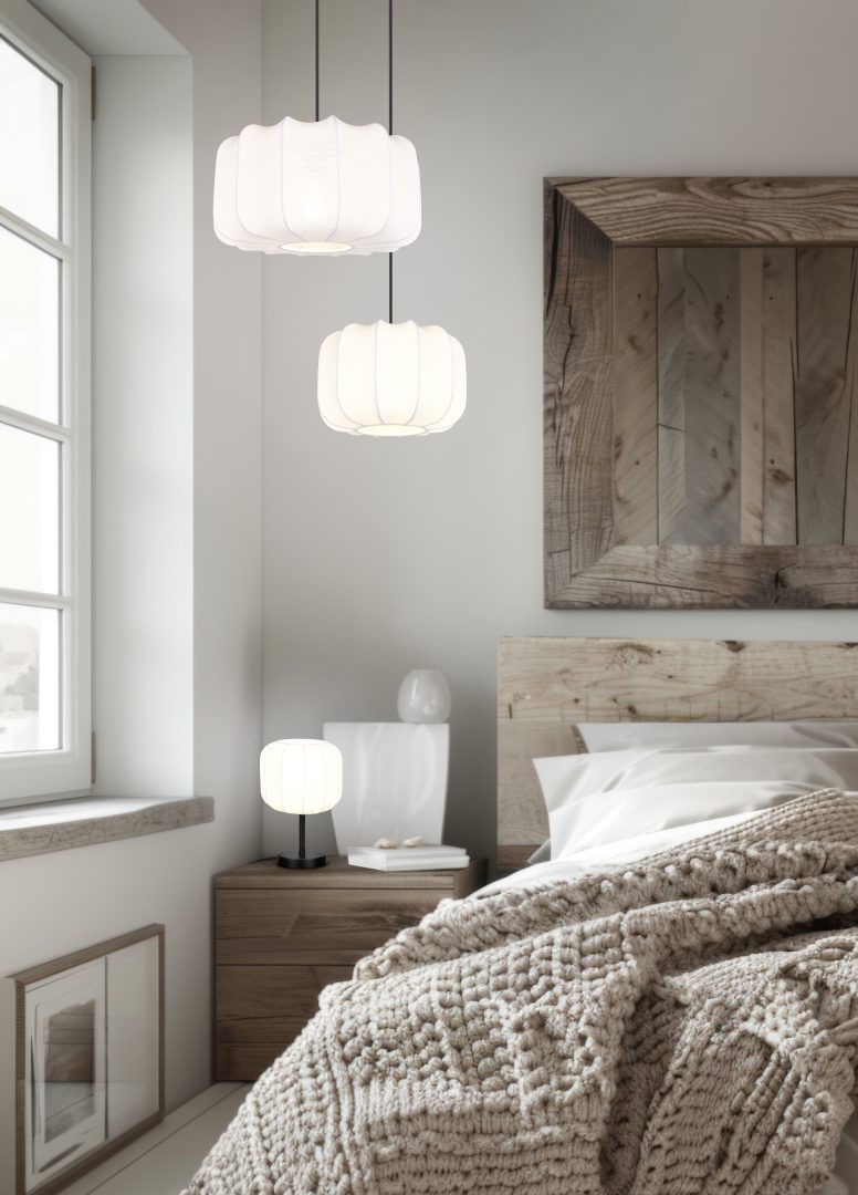 Gezellige slaapkamer met een houten bed, een beige deken met textuur en wit beddengoed. Hanglampen en een tafellamp met vergelijkbare witte ontwerpen verlichten de kamer. Een grote spiegel met houten frame en een raam zorgen voor extra decoratie en licht.