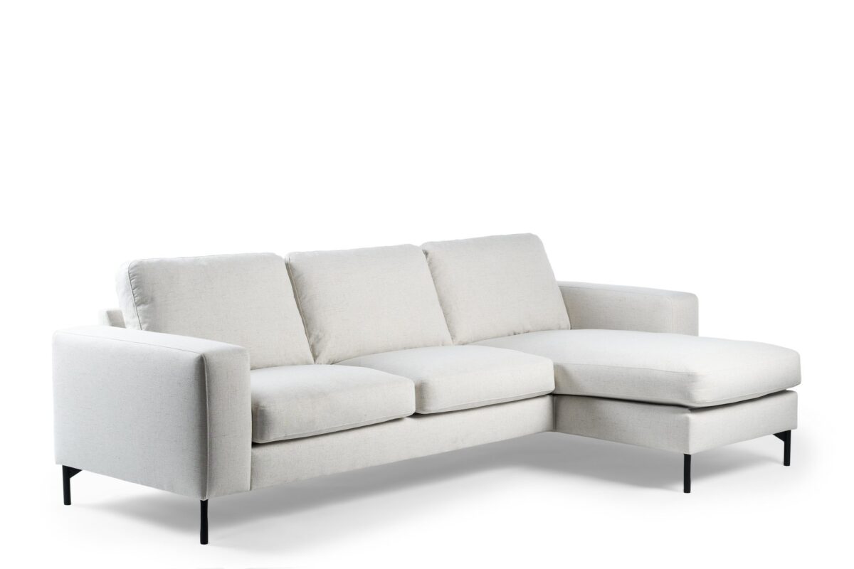 Een slanke 3-zitsbank, CL L+R in de stof Valente V920 naturel, heeft drie zit- en rugkussens, smalle armleuningen, zwarte metalen poten en een chaise lounge aan de rechterkant.