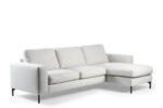 Een slanke 3-zitsbank, CL L+R in de stof Valente V920 naturel, heeft drie zit- en rugkussens, smalle armleuningen, zwarte metalen poten en een chaise lounge aan de rechterkant.