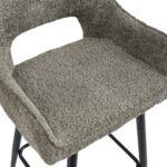 Close-up van een getextureerde, grijze barkruk met een rechthoekige uitsparing in de rugleuning. De kruk heeft zwarte metalen poten met een voetensteun. De bekleding heeft een zachte, ruige uitstraling.