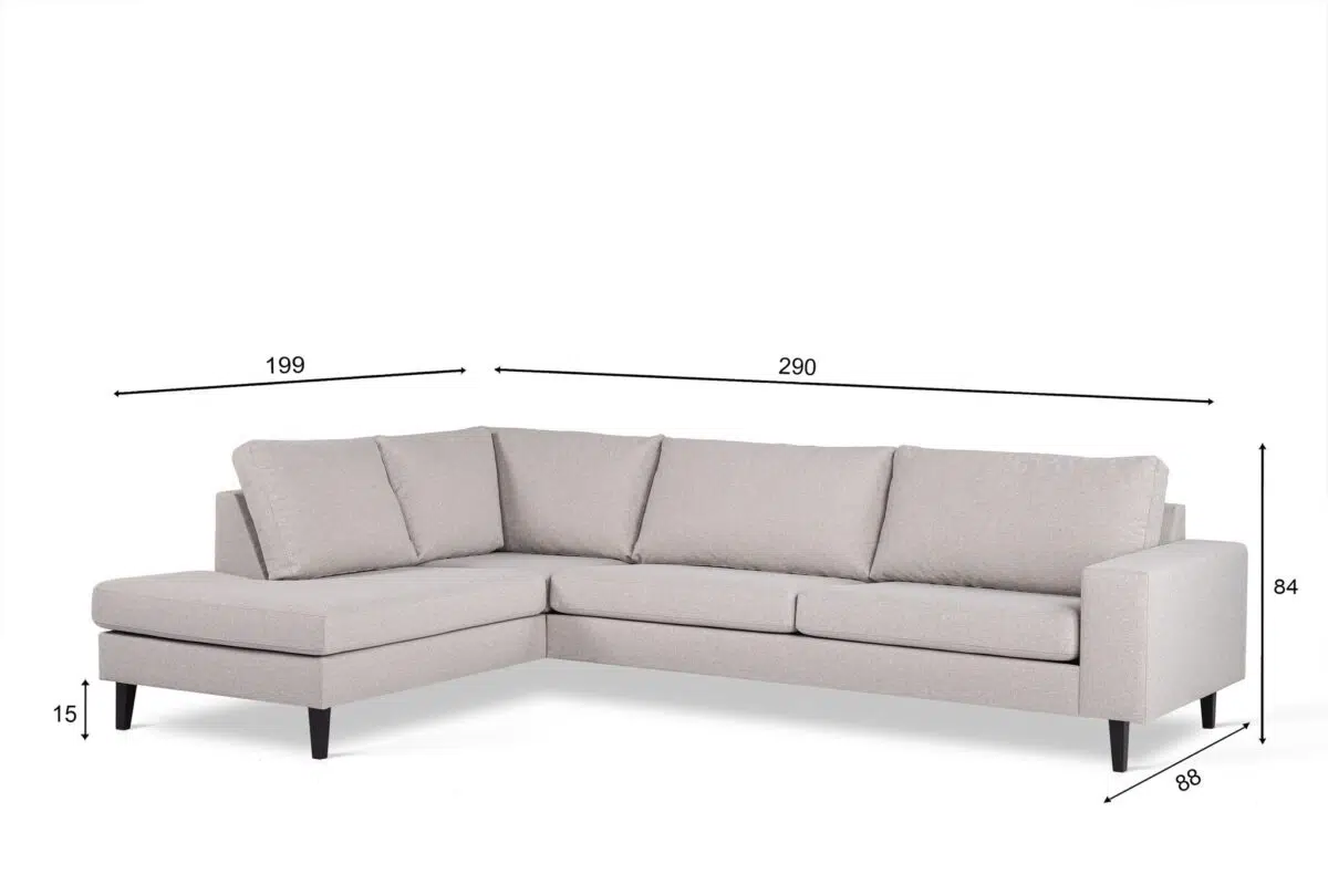 Een lichtgrijze L-vormige bank met drie zitkussens en een chaise longue aan de linkerkant. De bank heeft zwarte poten en de afmetingen zijn als volgt: 199 cm breedte voor de chaise longue, 290 cm totale breedte, 84 cm hoogte en 85 cm diepte.