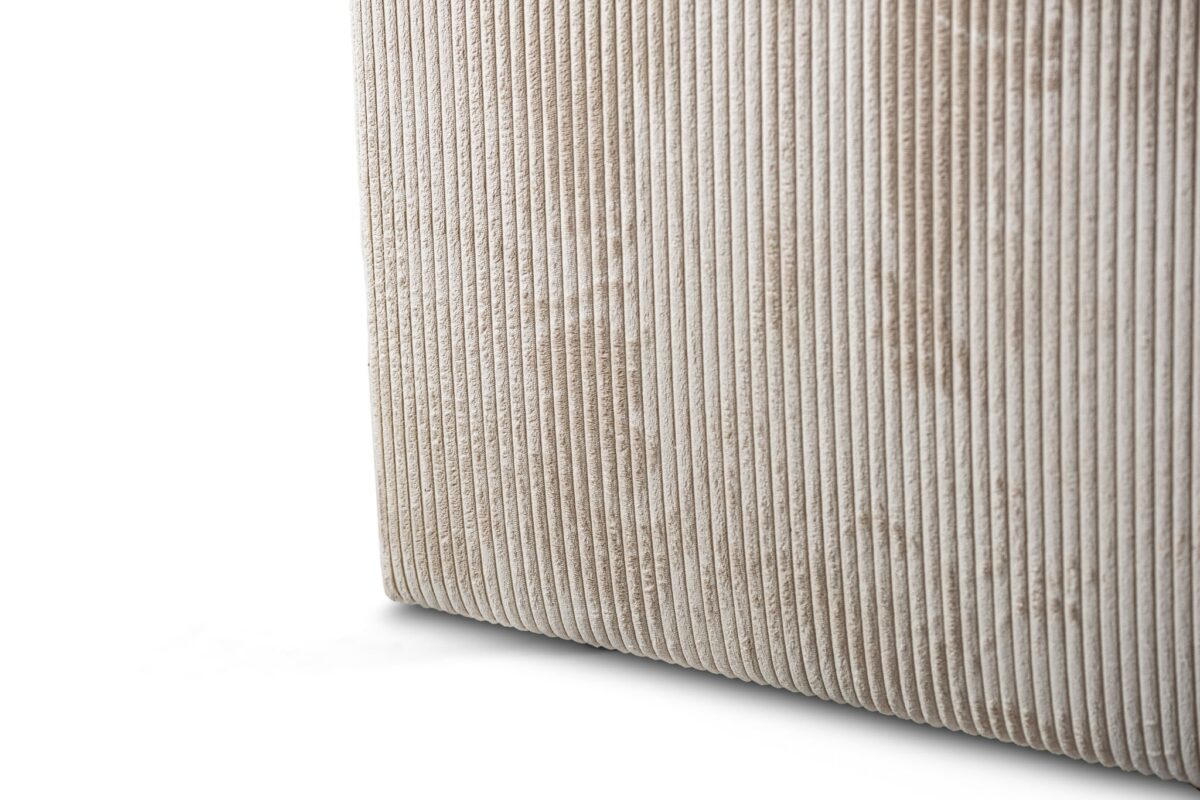 Close-up van de hoek van de 3 zits bank CL L+R in stof Lincoln 83 (RIB920 naturel), met de nadruk op de verticale ribbels en zachte textuur van het beige ribfluweel tegen een witte achtergrond.