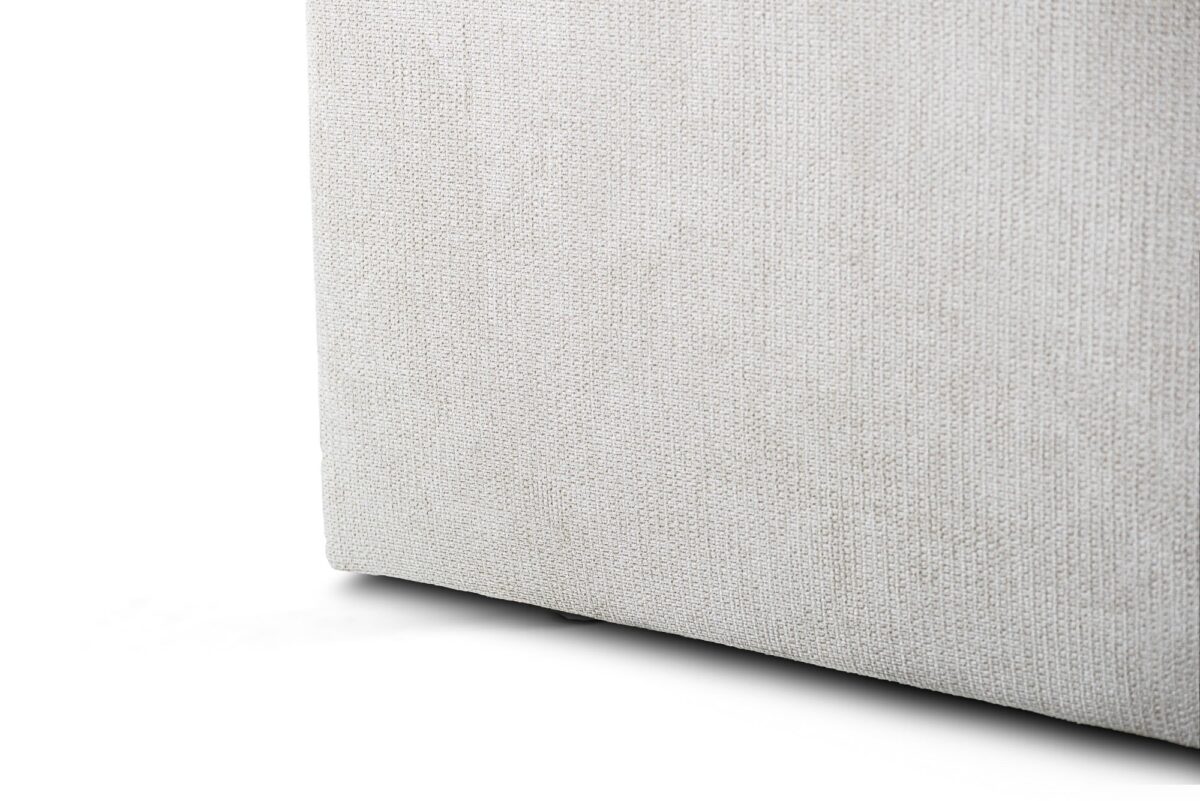 Close-up van de onderste hoek van een 3 zits bank CL L+R, stof Lord 22, E460 beige. De lichtbeige bekleding heeft een gestructureerd, strak geweven uiterlijk tegen een witte achtergrond.
