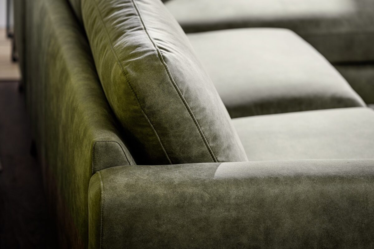 Close-up van de 3 zits bank CL L+R in Savannah stof, kleur S156 groen, met de groene suède-look bekleding, gladde armleuning en zacht rugkussen voor een comfortabele, moderne uitstraling.