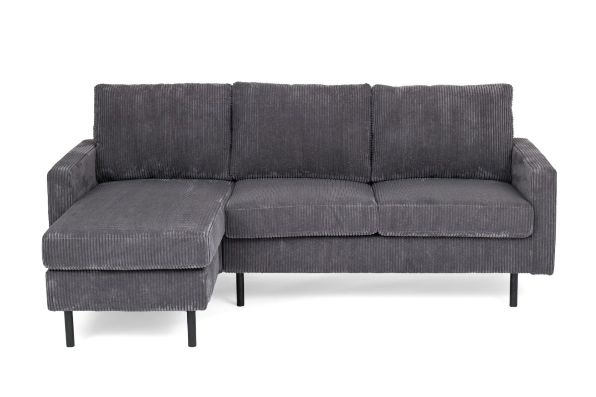 Een grijze corduroy L-vormige sectionele bank met dunne zwarte metalen poten. De bank heeft drie rugkussens en een verlengde chaise longue aan de linkerkant. De stof heeft een geribbelde textuur.