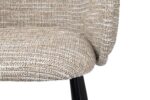 Close-up van een stoel met textuurstof met een gebogen rugleuning en zitting, met een geweven patroon van beige en bruine tinten. De stoel heeft zwarte metalen poten, gedeeltelijk zichtbaar op de afbeelding.