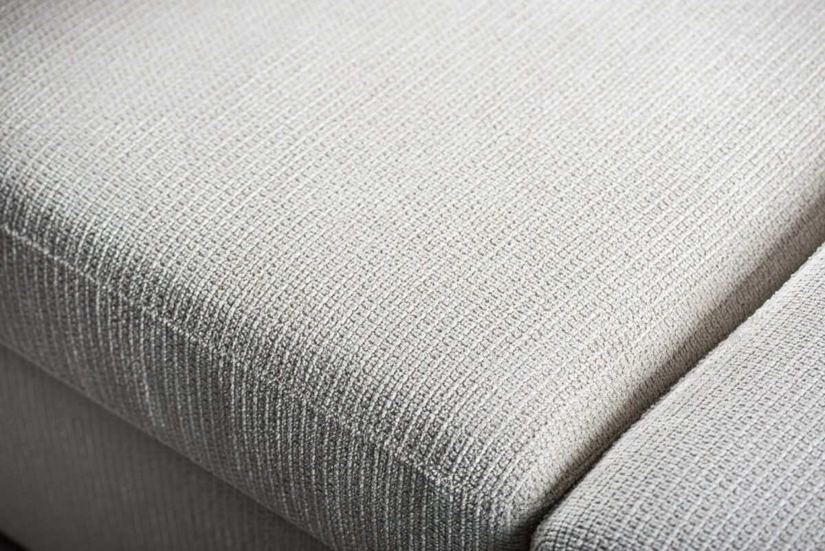 Close-up van de geweven textuur en stiksels op de 3 zits bank CL L+R in E460 beige Lord 22 stoffen bekleding.