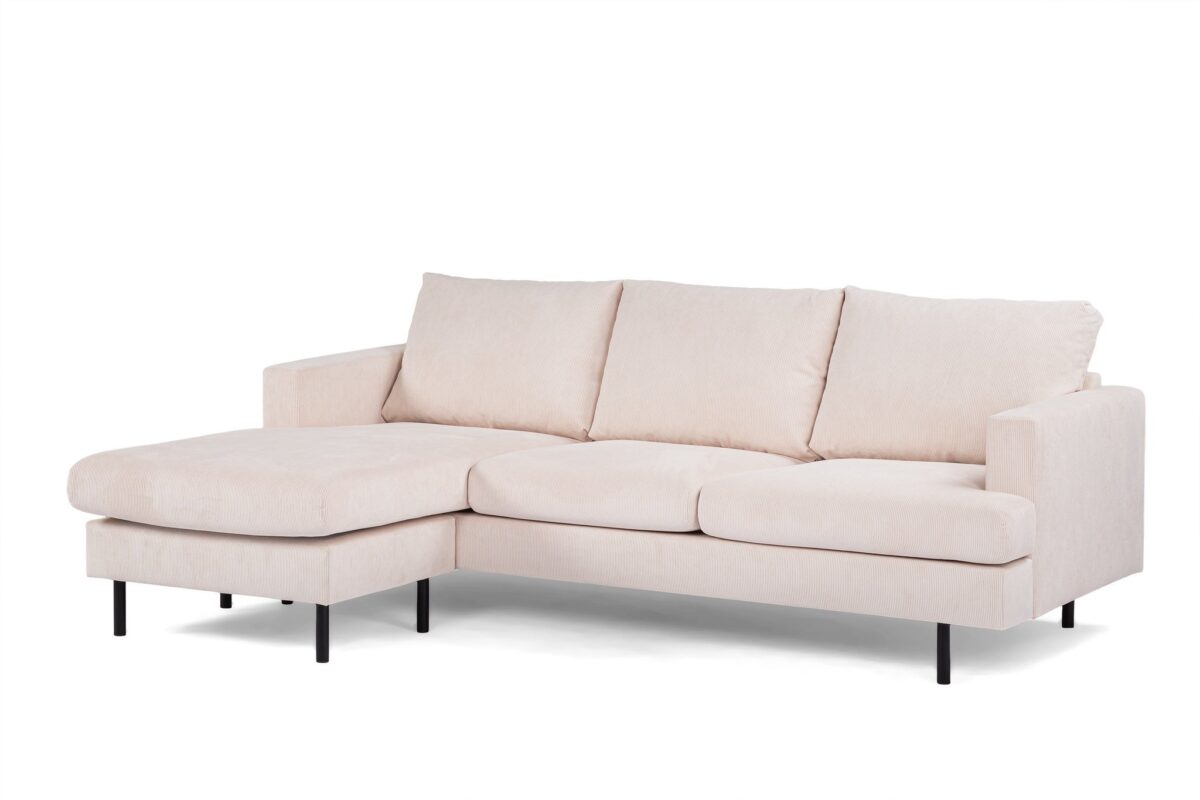 Beige L-vormige sectionele bank met drie grote rugkussens en strakke zwarte poten. De chaise longue staat aan de linkerkant, wat een modern en minimalistisch design creëert tegen een effen witte achtergrond.