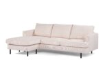 Beige L-vormige sectionele bank met drie grote rugkussens en strakke zwarte poten. De chaise longue staat aan de linkerkant, wat een modern en minimalistisch design creëert tegen een effen witte achtergrond.