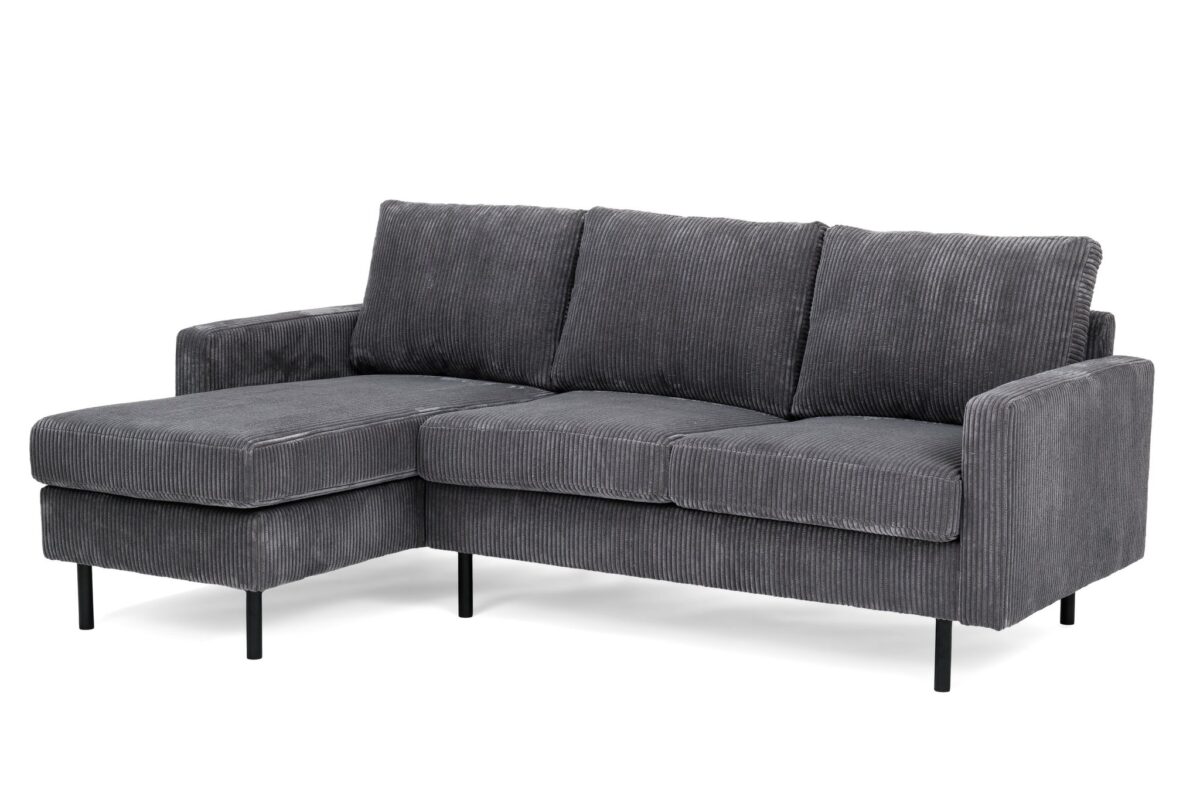 Grijze sectionele bank met corduroy bekleding en drie kussens. De bank heeft een chaise longue aan de linkerkant en rust op slanke zwarte metalen poten, wat hem een moderne uitstraling geeft.