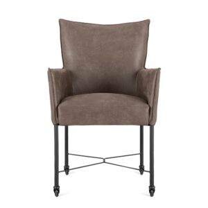 De Eetkamerstoel Maastricht Donker bruin is een moderne fauteuil met donkerbruine bekleding, licht uitlopende armleuningen, een hoge rugleuning, slanke zwarte metalen poten met een X-vormig stretchgedeelte en kleine wieltjes onder de voeten.