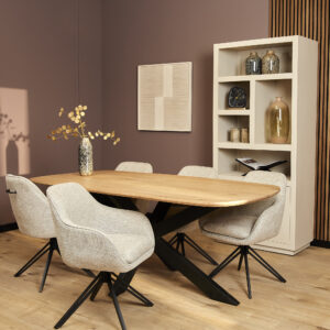 Moderne eetkamer met een lichte houten tafel, vijf Eetkamerstoel Jens | Beige stoelen, een hoge witte boekenkast met decoratie, geometrische wandkunst en een vaas met gouden takken op tafel.