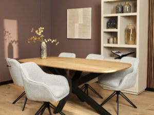 Moderne eetkamer met een houten tafel, vijf Eetkamerstoel Jens stoelen in lichtgrijs, een decoratieve vaas met takken, een crèmekleurige plank met decoratiestukken en mauvekleurige muren.