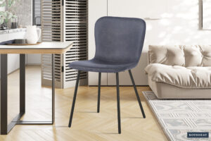 Een moderne kamer met Stoel 'Susan' PU Donkergrijs stoelen (2 per doos) met zwarte metalen poten, geplaatst op een lichte houten visgraatvloer naast een beige bank, een kleine eettafel en een witte kast.