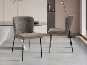Twee Stoel 'Lisa' Bouclé Zand stoelen (set van 2) met een modern design staan in een chique eetkamer, gecombineerd met een witte tafel en een modern interieur tegen neutrale muren.