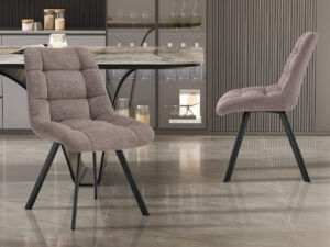 Twee Stoel 'Lizzy' stoelen in Ote Share 400 Peper stof met zwarte metalen poten staan op een glimmende tegelvloer in een moderne keuken met marmeren aanrechtbladen en glazen kasten. (2 per doos).