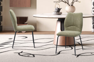 Twee Stoel 'Lara' Stof Ote Sea 173 Zand stoelen staan bij een ronde tafel met een wit marmeren blad en een houten onderstel, op een beige kleed met abstracte zwarte lijnen in een moderne, minimalistische kamer.